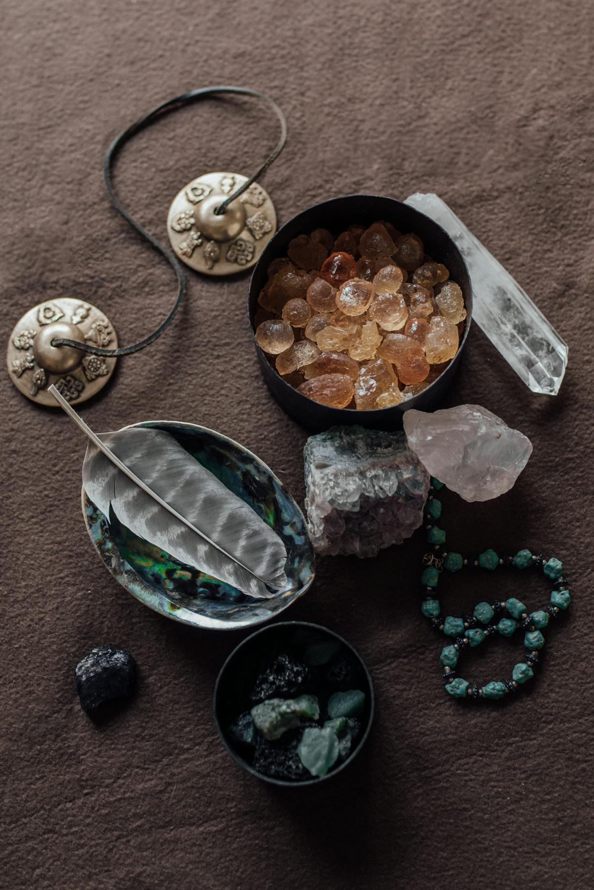 Bol de pierres de calcite orange avec cymbales tibetaines pour le chakra sacre Svadhisthana
