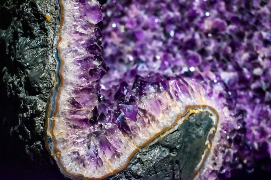 Géode améthyste ouverte aux cristaux violets posée dans un intérieur clair