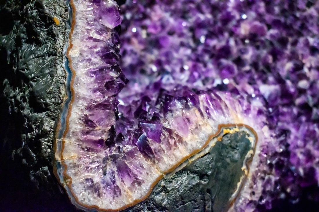 Géode améthyste ouverte aux cristaux violets posée dans un intérieur clair