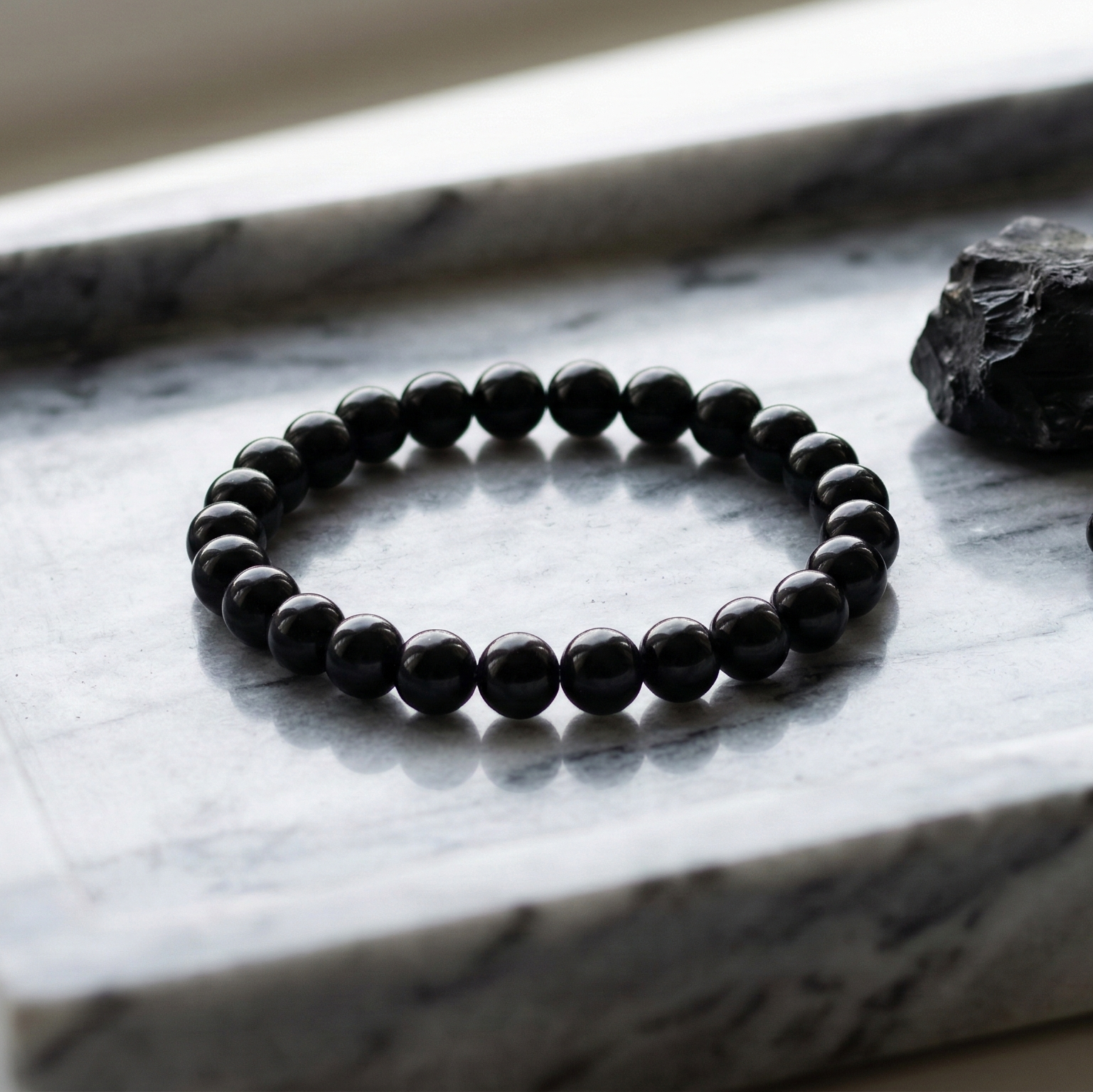 Bracelet onyx noir perles polies gros plan protection