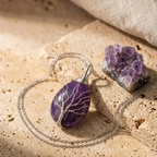 Collier arbre de vie améthyste posé sur sable avec druse violette brute