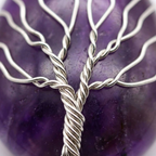 Détail du fil argenté torsadé en arbre de vie sur l'améthyste violette