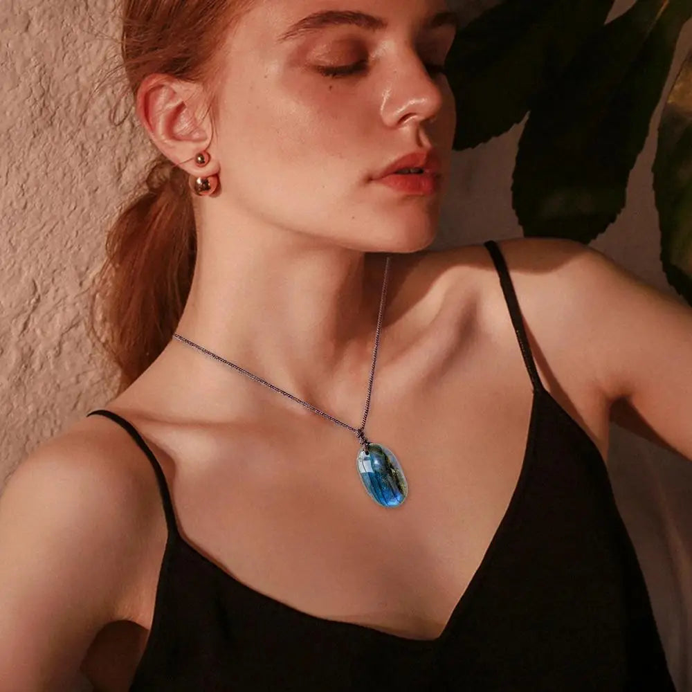 Pendentif labradorite aux reflets bleus vu de près sur fond clair