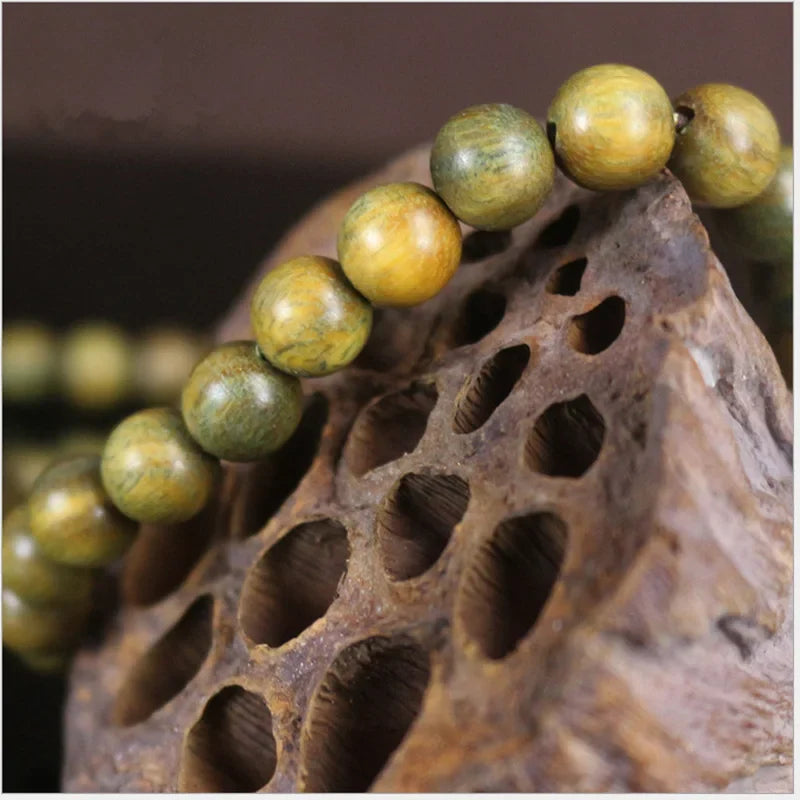 Bracelet mala en bois de santal vert porté en 5 tours au poignet