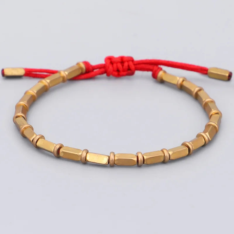 Bracelet tibétain en cuivre doré porté au poignet, cordon noir