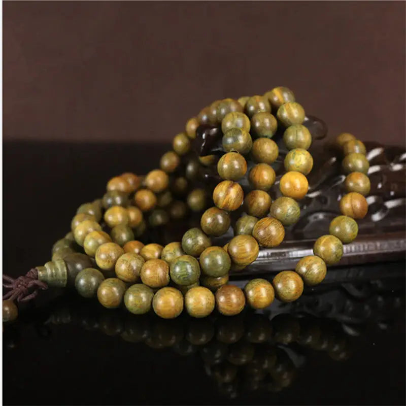 Macro du veinage vert-brun des perles du bracelet mala en santal