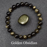 Bracelet obsidienne dorée de perles 8 mm au poignet, voile doré visible en lumière rasante