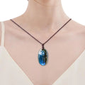 Collier labradorite naturelle porté, galet poli sur cordon tressé brun