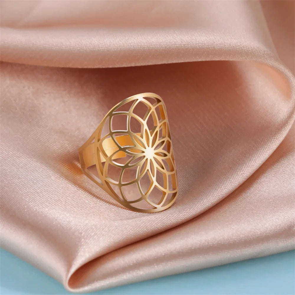 Bague fleur de vie ajourée en acier inoxydable doré portée à la main