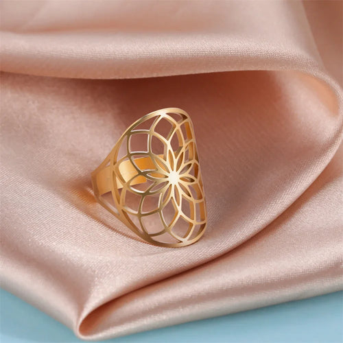 Bague fleur de vie ajourée en acier inoxydable doré portée à la main