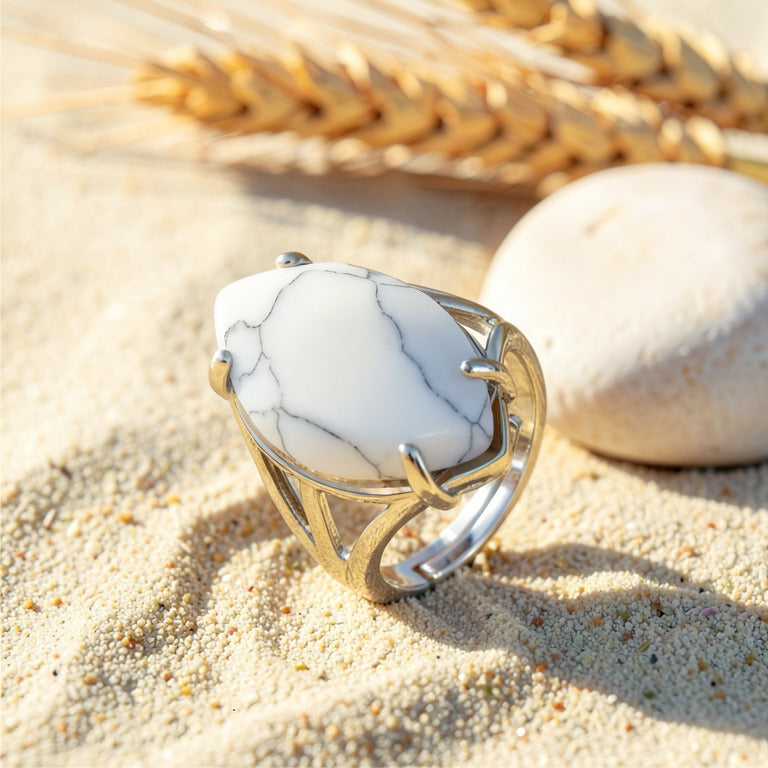 Bague Howlite réglable en métal argenté, cabochon marquise, posée sur le sable