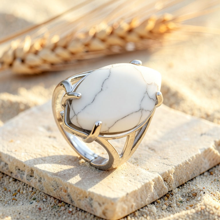 Bague Howlite réglable, monture ajourée argentée, sur une dalle de pierre claire