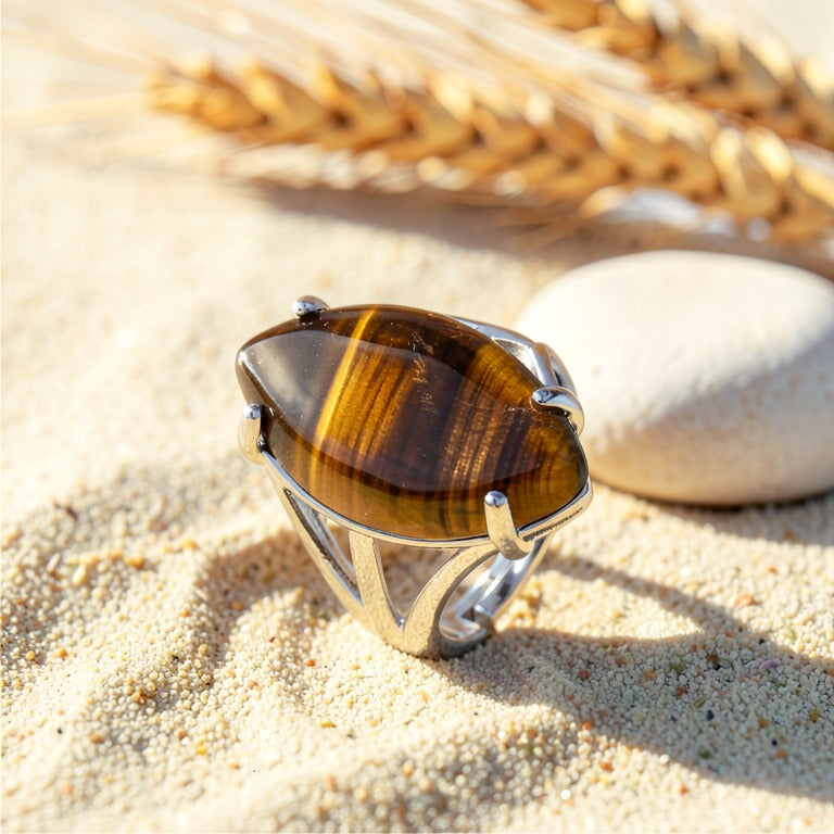 Bague Œil de Tigre réglable en métal argenté, cabochon marquise, posée sur le sable